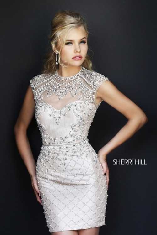 Взять в прокат Женская одежда Платья SHERRI HILL SH035 Москва Взять в прокат Женская одежда Платья SHERRI HILL SH035; Москва , г.Москва, Малый Конюшковский переулок, дом 2 (Галерея MOD DESIGN) ул.; Описание: Назначение: романтический вечер, студийная или выездная фотосессия, новогоднее торжество, корпоративная вечеринка, празднование дня рождения.
Описание модели: элегантное, короткое платье из тонкой прозрачной ткани, расшитой стразами, бисером и пайетками. Вырез под горло, с небольшими плечиками. Лиф с чашечками. Внутренняя ткань выполнена из тафты. Открытая спинка в виде ромбика.